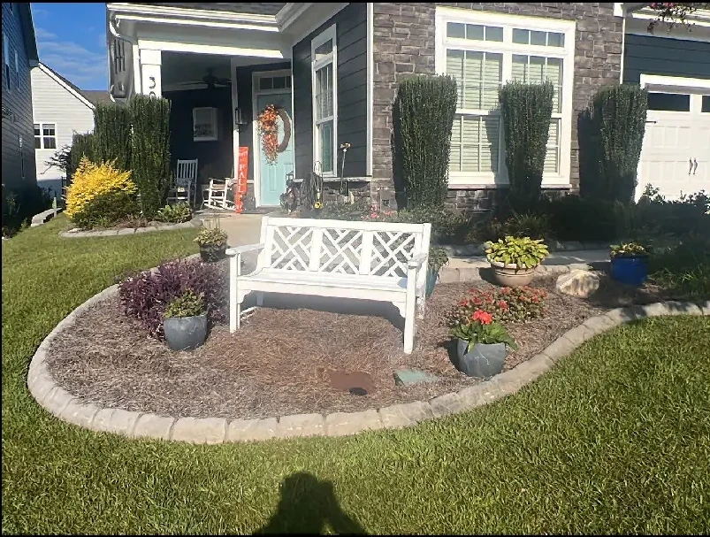 Landscape design with stone patio, bench, and professional plantings